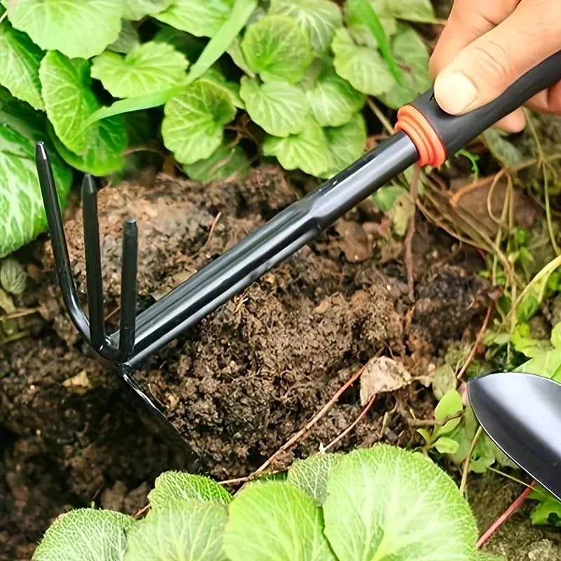Un juego de cuatro herramientas de jardinería para exteriores que incluye una pala pequeña para plantar flores, un rastrillo de cinco puntas y un rastrillo de dos cabezas.