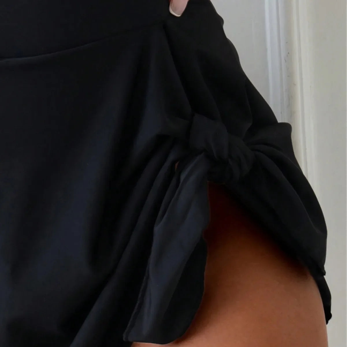 Traje de baño de una pieza de estilo deportivo conservador para mujer con diseño de tirantes cruzados y falda integrada.
