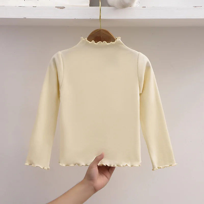 Ropa para niños, nueva camiseta básica para niñas de otoño e invierno, camiseta de manga larga de color liso con borde de hongo negro a la moda para niños.