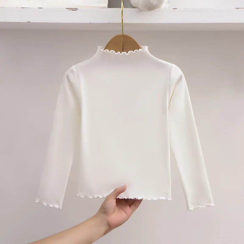 Ropa para niños, nueva camiseta básica para niñas de otoño e invierno, camiseta de manga larga de color liso con borde de hongo negro a la moda para niños.