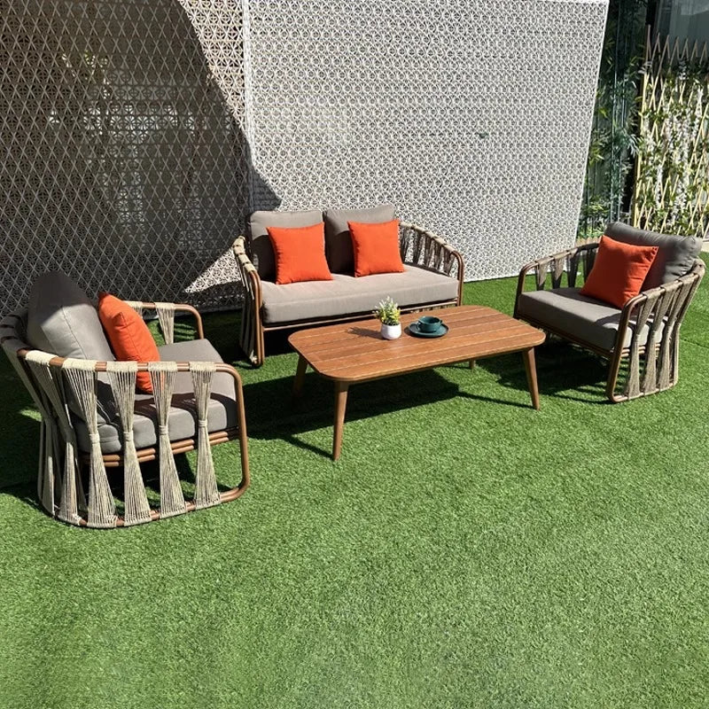 Moderno conjunto de muebles de exterior de aluminio con aspecto de madera, sofá de ratán y mesa de centro para patio, balcón, terraza o salón de jardín de hotel.