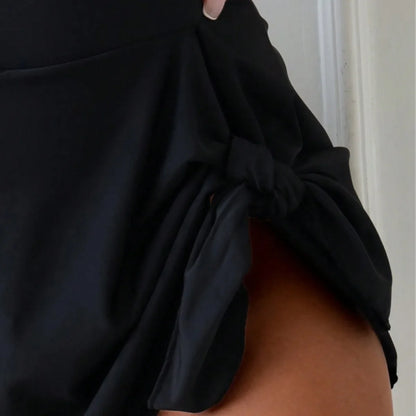 Traje de baño de una pieza de estilo deportivo conservador para mujer con diseño de tirantes cruzados y falda integrada.