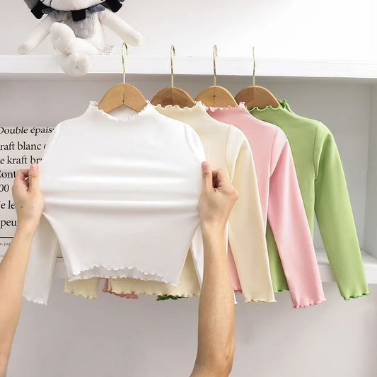Ropa para niños, nueva camiseta básica para niñas de otoño e invierno, camiseta de manga larga de color liso con borde de hongo negro a la moda para niños.
