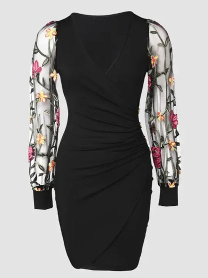 Elegante vestido midi ajustado con bordado floral, mangas de malla transparente y escote en V. Detalle de botones con estilo. Largo hasta la rodilla.