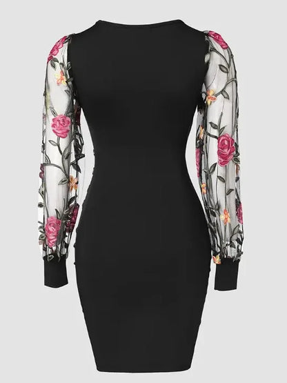 Elegante vestido midi ajustado con bordado floral, mangas de malla transparente y escote en V. Detalle de botones con estilo. Largo hasta la rodilla.