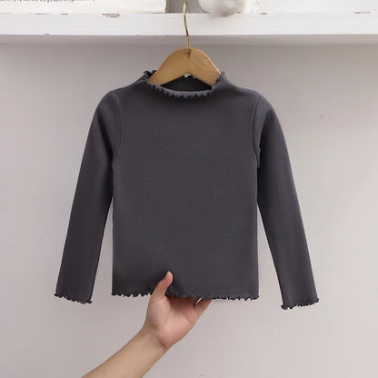 Ropa para niños, nueva camiseta básica para niñas de otoño e invierno, camiseta de manga larga de color liso con borde de hongo negro a la moda para niños.
