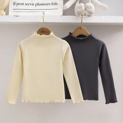 Ropa para niños, nueva camiseta básica para niñas de otoño e invierno, camiseta de manga larga de color liso con borde de hongo negro a la moda para niños.