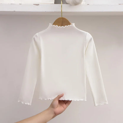 Ropa para niños, nueva camiseta básica para niñas de otoño e invierno, camiseta de manga larga de color liso con borde de hongo negro a la moda para niños.