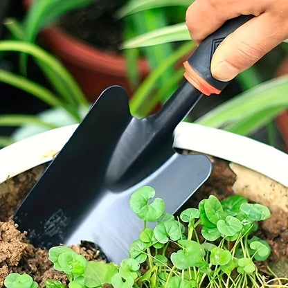Un juego de cuatro herramientas de jardinería para exteriores que incluye una pala pequeña para plantar flores, un rastrillo de cinco puntas y un rastrillo de dos cabezas.